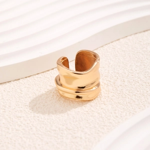 Detailansicht eines goldenen Lavarmreifs mit unregelmäßiger Wellenstruktur und offenem Design