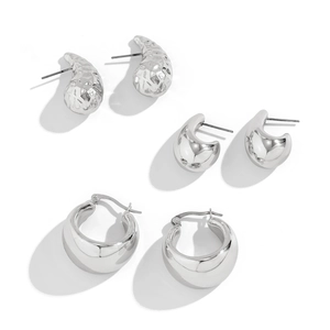 Detailansicht der silbernen Wassertropfen-Ohrstecker und geometrischen Ohrringe