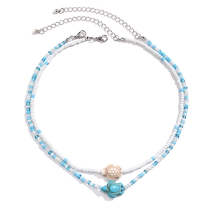 Close-up of double-layer beaded necklace featuring turquoise and resin turtle pendants