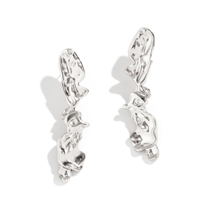 Close-up of silver irregular liquid metal earrings with a molten texture and avant-garde style
