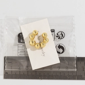 Ear cuff dorato a forma di C con perline, misura di 20mm su un righello