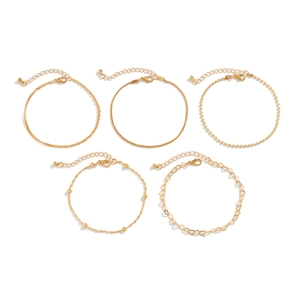 Detail of 5-piece gold anklet set featuring heart charms and diverse link chains