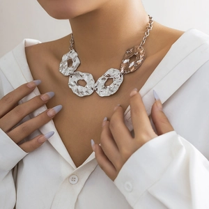 Detail of irregular metallic liquid necklaces with hammer textured silver and gold rings