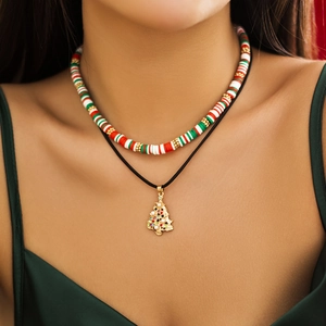 Close-up of a festive double-layer beaded necklace with a gold Christmas tree pendant