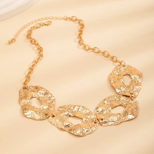 Detail of irregular gold hammered metal necklace featuring fluid geometric disk pendants