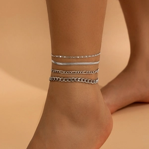 Detail of silver layered anklet set with snake, Figaro, and Cuban chain textures