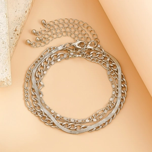 Detail of multi-layered silver ankle chain with Figaro and snake bone link patterns