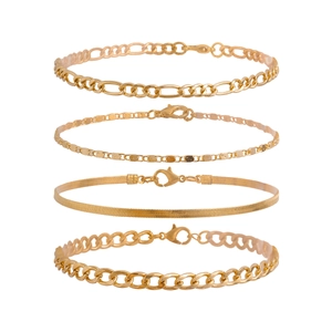 Detail of four-piece gold anklet set featuring snake chain and figaro chain designs