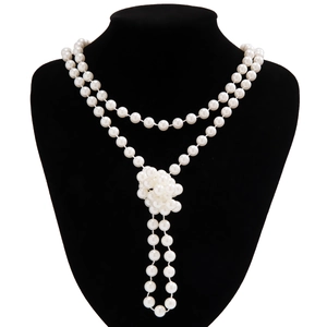 Detail van elegante meerlagige parelketting met dubbele streng en parelmoer bloemenknoop