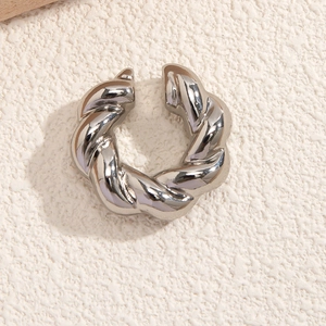 Dettaglio macro di un orecchino ear cuff a tortiglione in argento lucido minimalista