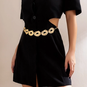 Close-up of golden belt featuring hammered texture irregular discs on black dress
