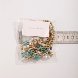 Close-up of colorful seed beads and starfish pendants with ruler for size reference