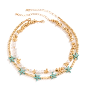 Close-up of double-layered beaded necklace with turquoise starfish and shell charms