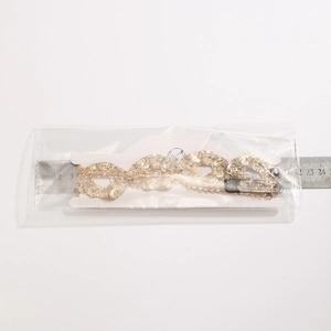 Macro view of gold irregular hammered disc necklace showing detailed texture and size