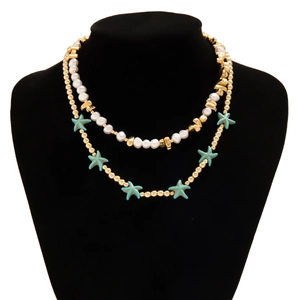 Close-up of double-layer beaded necklace with white pearls and blue starfish charms