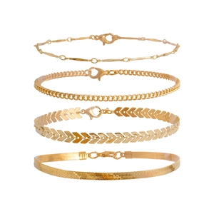 Detail of four-piece gold anklet set featuring cuban, snake, and fishbone chains