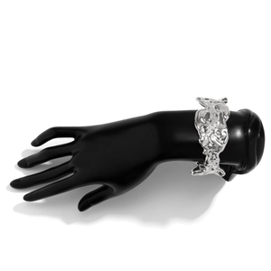 Detail of silver liquid metal wide cuff bracelet with lava texture on black hand model