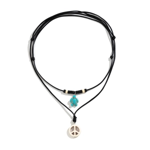 Detail of layered beach necklace featuring a turquoise turtle and white peace sign charm
