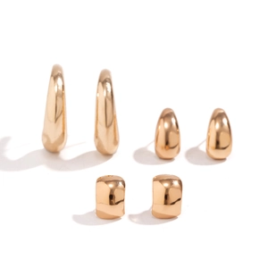 Detailansicht der polierten goldenen Tropfenohrringe und geometrischen Stecker