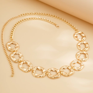Close-up of golden irregular wavy circle links on a stylish adjustable waist chain