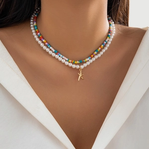 Detail of layered bohemian necklace featuring white pearls, colorful beads, and a starfish pendant