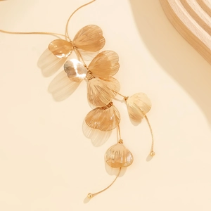 Vue détaillée de pendentifs feuilles de ginkgo dorées avec texture striée sur chaîne