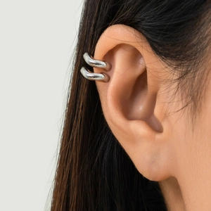 Makroansicht der minimalistischen silbernen Doppel-Ohrklemme mit hochglanzpoliertem Metall