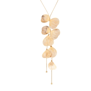 Détails de pendentifs feuilles de ginkgo dorées texturées sur une longue chaîne élégante