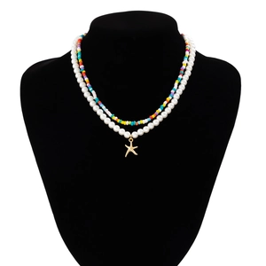Detail of layered bohemian necklace with colorful seed beads, pearls and starfish pendant