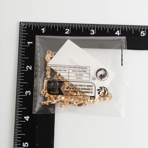 Detailed size measurement of a gold liquid metal choker necklace with a ruler