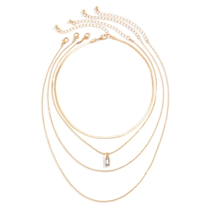 Macro detail of a four-layer gold-plated necklace set featuring a smooth snake chain and zircon