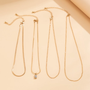 Detail of four-piece gold necklace set featuring sleek snake chain and zircon pendant
