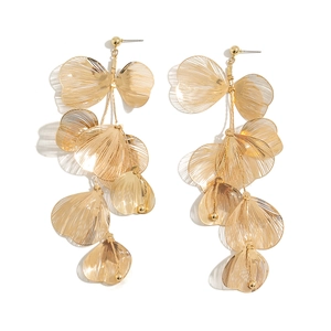 Détail de boucles d'oreilles feuilles de ginkgo dorées avec textures métalliques creuses