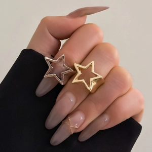 Minimalist gold and silver hollow star ring set shown on hand in a stylish aesthetic