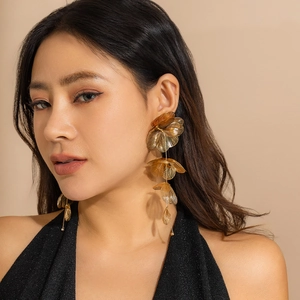 Vue détaillée de boucles d'oreilles fleurs dorées vintage avec textures superposées