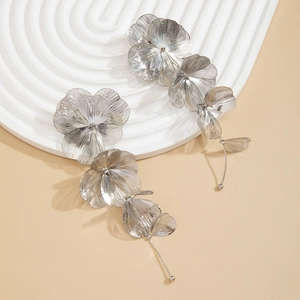 Détail de boucles d'oreilles pendantes en argent avec pétales et pampilles à boule
