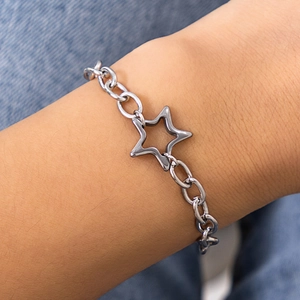 Detailed view of silver star pendant on a chunky link chain bracelet worn on wrist