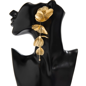 Détail de pétales de feuilles dorés superposés et chaînes à glands sur mannequin noir