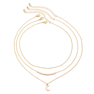 Detailed view of triple-layered gold necklaces with moon pendant and curved metal bar