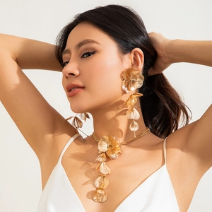 Détail de l'ensemble collier et boucles d'oreilles feuilles de ginkgo dorées sur mannequin