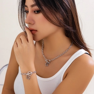 Close-up of a silver stainless steel star pendant necklace and bracelet set with OT clasp