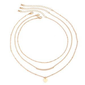 Detailed macro view of triple-layered gold necklaces with snake chain and bead accents