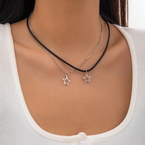 Detailed view of layered star pendant necklace with black cord and silver-tone chain