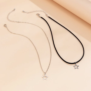 Detailed view of silver star pendants on thin metal chain and black cord necklaces