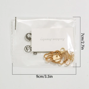 Detail of gold letter J pendant necklace packaged in a branded jewelry display bag