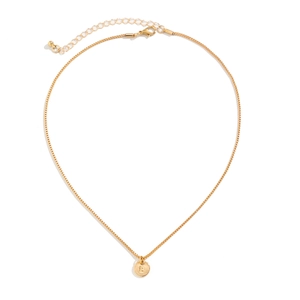 Macro shot of gold-plated round pendant with engraved letter B and lobster clasp