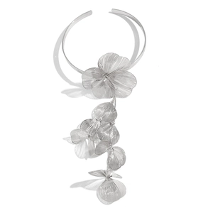 Détail macro du collier ras du cou ginkgo argenté au design floral superposé