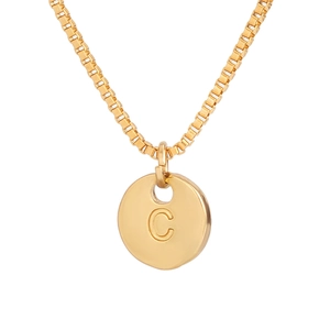 Detail of golden box chain and round pendant with engraved letter C on white background