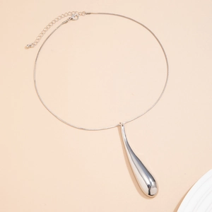 Détail d'un pendentif goutte d'eau poli sur un collier avec chaîne de serpent