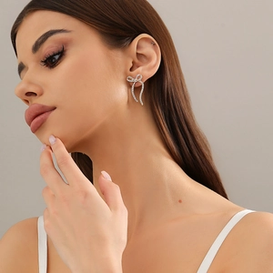 Detailansicht eleganter Schleifen-Ohrstecker mit funkelnden Kristallen an einem Model